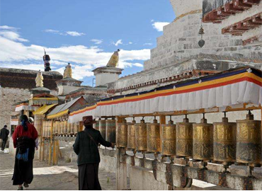Standing on the entrance of Tashilhunpo,visitors can see the grand buildings with golden roofs and white walls Standing on the entrance of Tashilhunpo,visitors can see the grand buildings with golden roofs and white walls