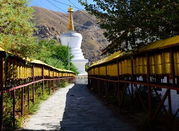 An alley of prayer wheels leading up to a pagoda. An alley of prayer wheels leading up to a pagoda.